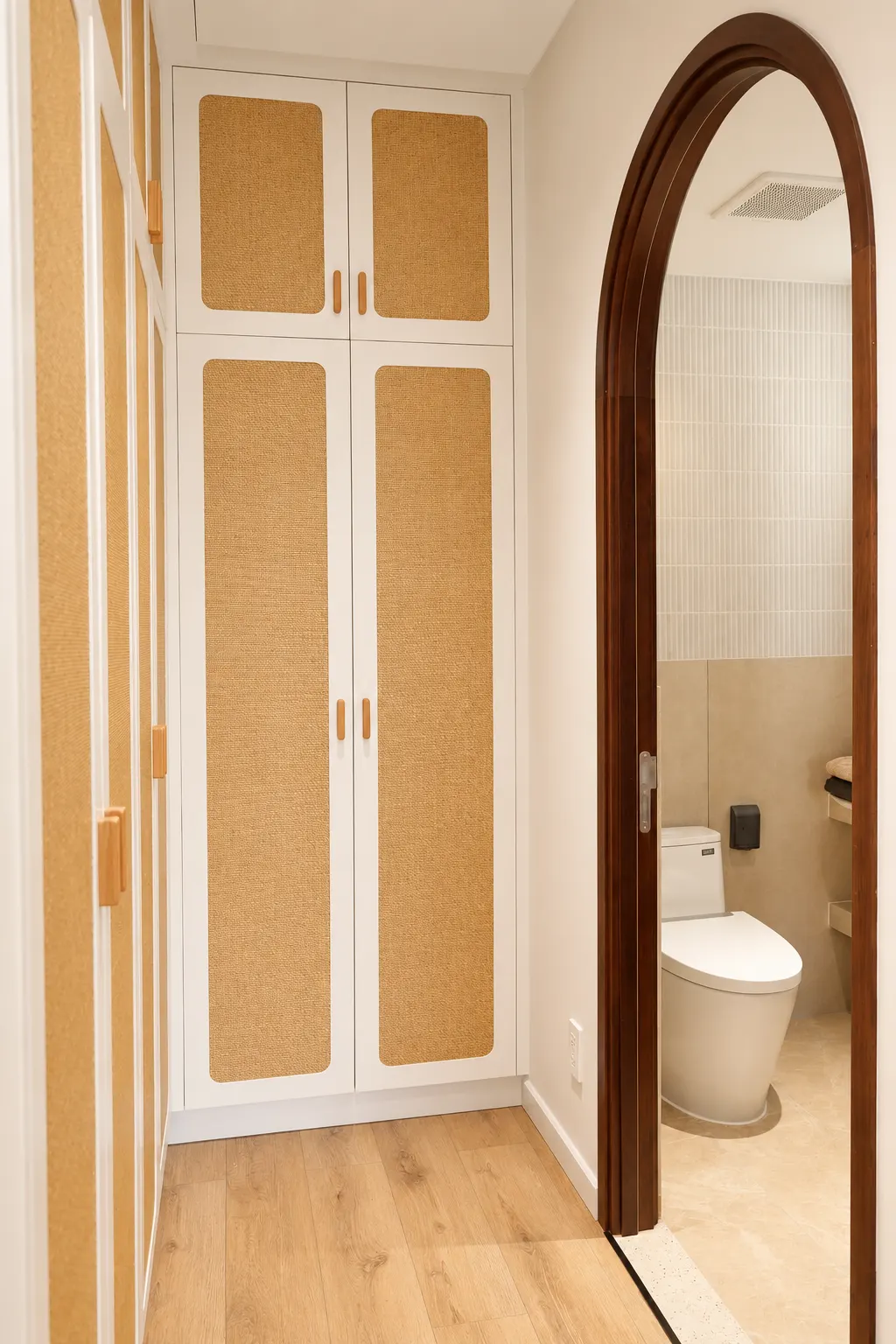 Built-in hallway storage beside an arched bathroom doorway
